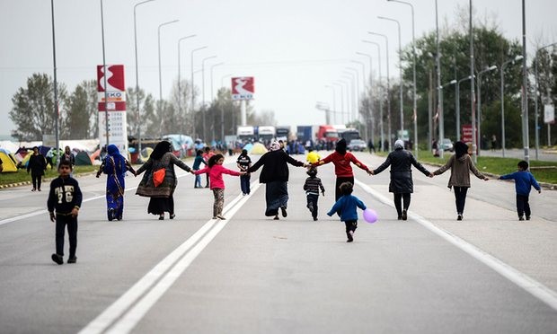 Migrants hold hands as they block the highway near the town of Polykastro in northern Greece in protest at the closure of the border with Macedonia. Photograph: Bulent Kilic/AFP/Getty Images